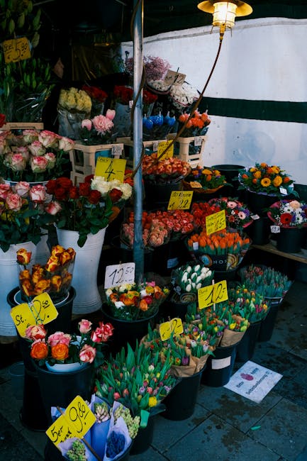 A wide display of fresh flowers at a flower market stand, offered by flowerskeston.co.uk. The arrangement includes pink and white roses, vibrant tulips in various colors, and mixed floral bouquets arr
