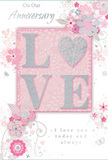 This anniversary card appears like a tender love note laid out in soft daylight, its colours and textures reflecting the gentle romance often celebrated with flowers across Keston. At the centre, the word LOVE is spelled in raised, softly rounded letters, their surface glazed with fine, blush-pink glitter and hints of silver that twinkle as if scattered starlight. One letter subtly incorporates the shape of a heart, giving the design an extra touch of intimacy. The surrounding artwork is a dreamy composition of delicate blooms, tiny buds, and curling tendrils, all illustrated in pastel pinks, mauves, and silvery greys that recall the muted tones of early spring blossoms in local gardens near Keston Common. The flowers feel both stylised and graceful, with petals shaded just enough to suggest depth, like a floral designer at Flowers Keston sketching ideas for an anniversary bouquet to be delivered same-day to a nearby home. Wispy swirls and fine lines weave between the blossoms, adding movement and lightness, while subtle butterflies or petal-like flourishes create a sense of gentle celebration. The heartfelt phrases On Our Anniversary and I love you today and always are written in an elegant, flowing script that curls like trailing foliage around the central motif. Altogether, the card radiates soft, enduring affection and the quiet joy of shared years, mirroring the sentiment of a carefully chosen arrangement from a trusted local florist.